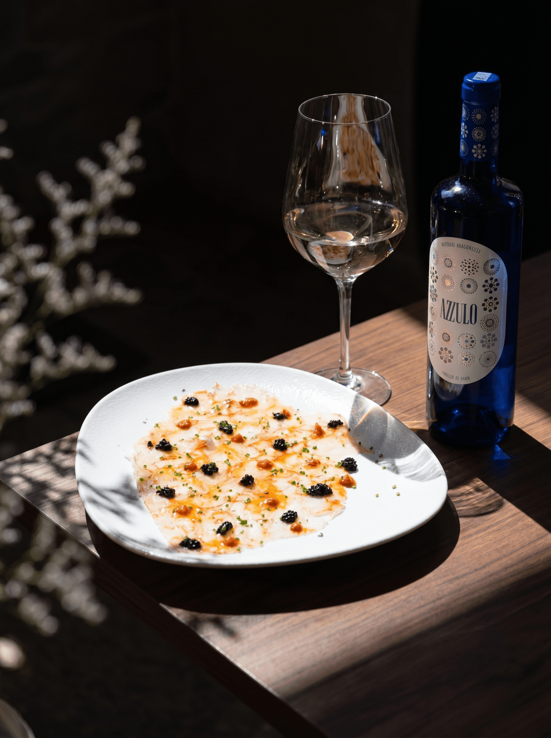 Carpaccio de gamba roja con coral y huevas de arenque, con una copa de blanco · Acontramar, La Herradura