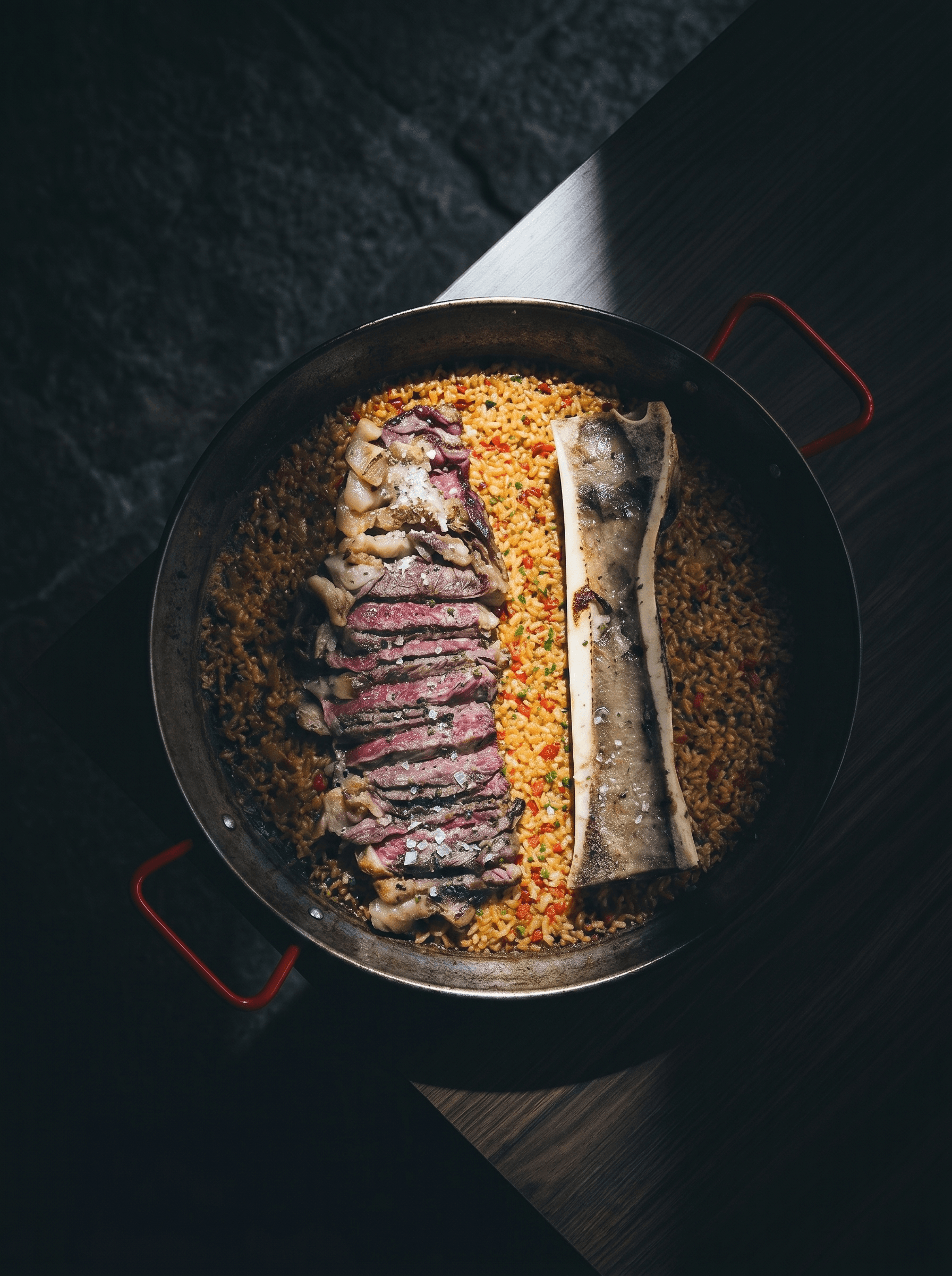 Rice with sliced aged beef and roasted marrow bone, in the pan · Acontramar, La Herradura